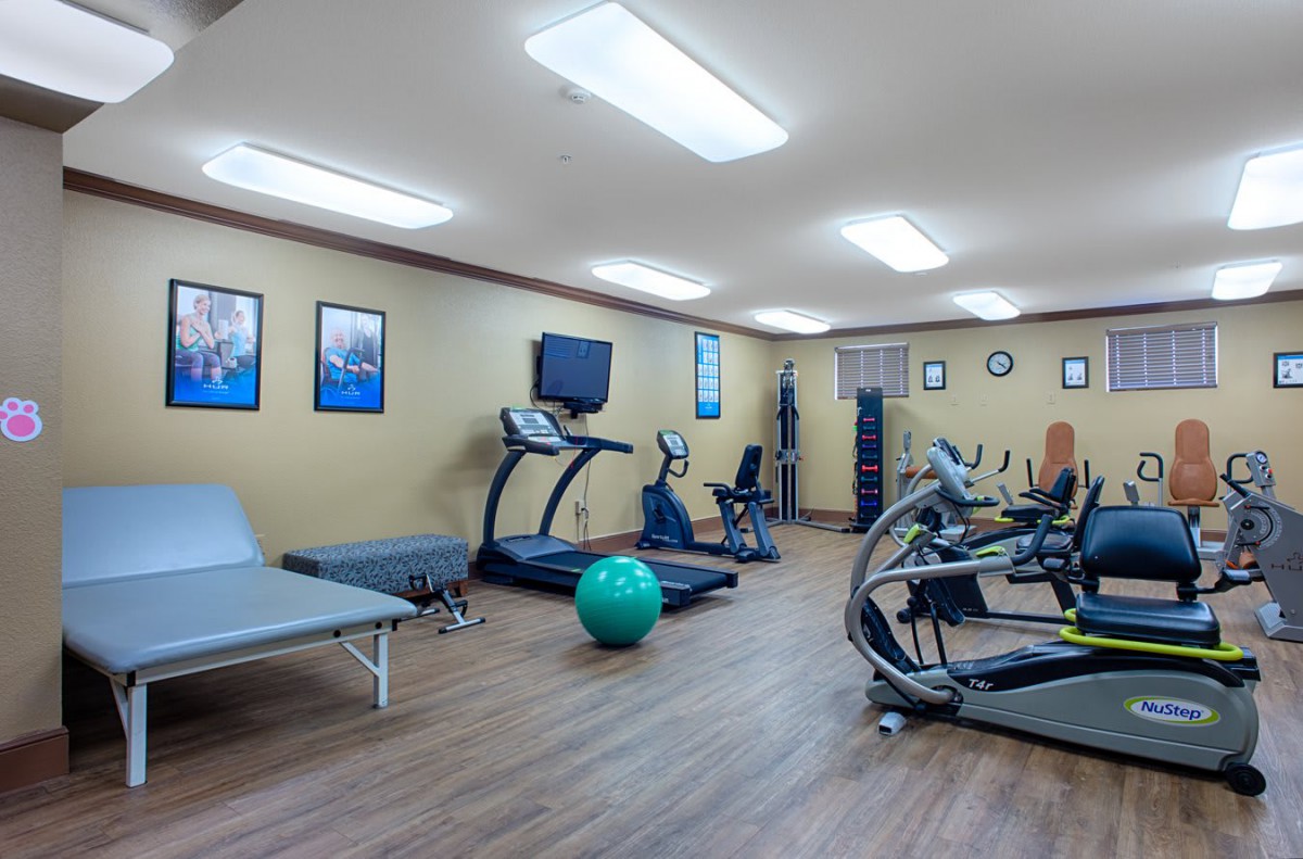 A well-equipped fitness center with exercise machines and a yoga ball.