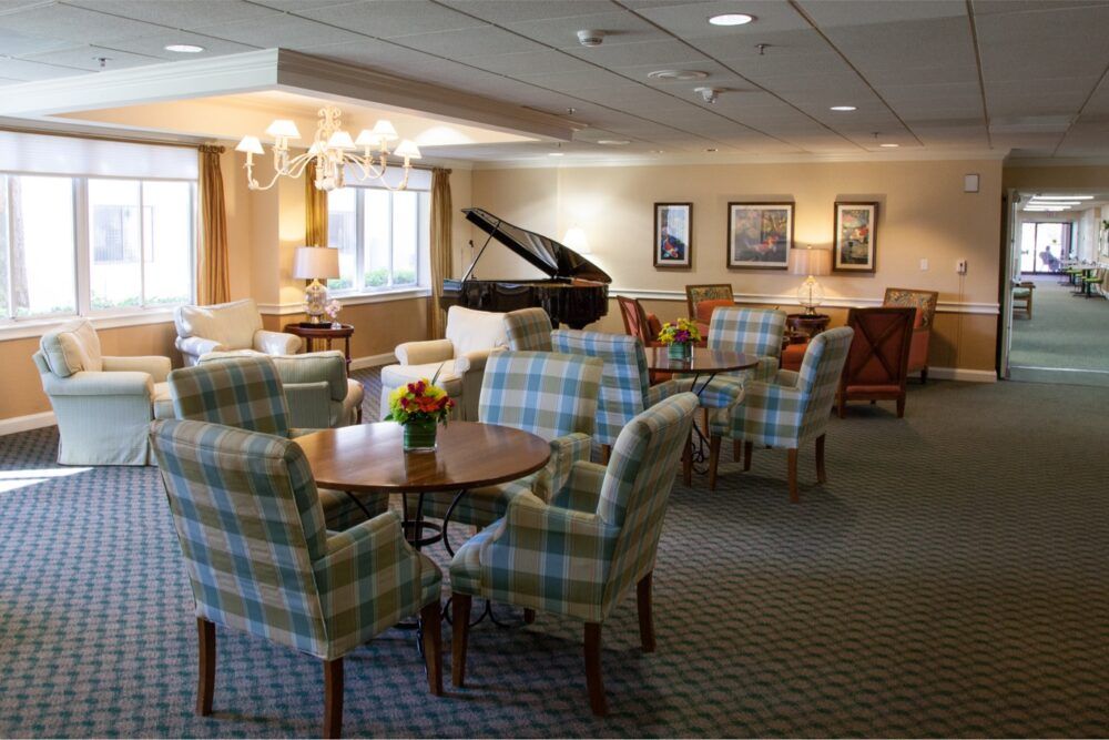A cozy lounge area featuring a grand piano, comfortable seating, and warm lighting.