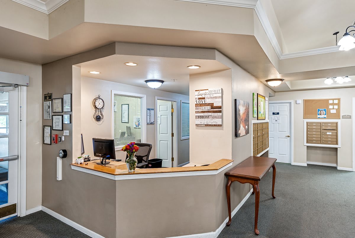 A well-organized office reception area with a desk, artwork, and subtle lighting.