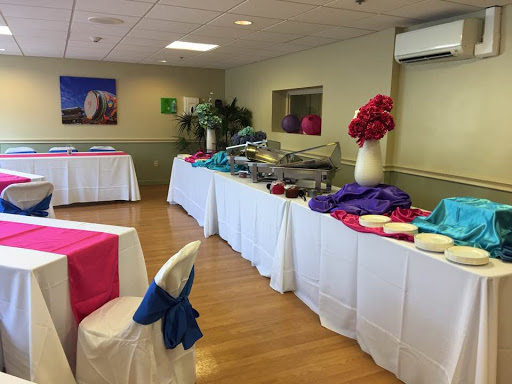 A well-decorated event space featuring colorful table linens and a food station.