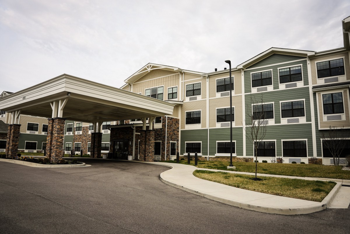 A modern commercial building with a covered entrance and driveway.