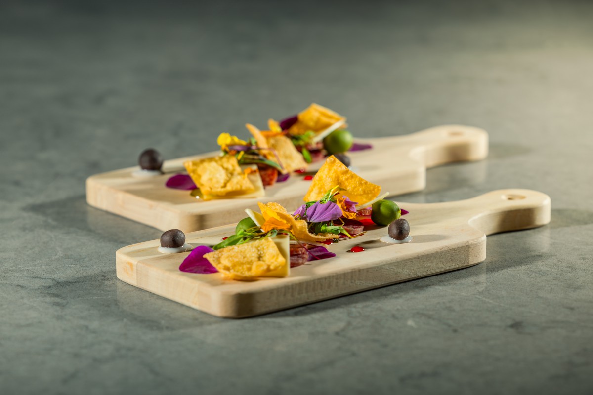A beautifully plated gourmet dish featuring a creative arrangement with edible flowers.
