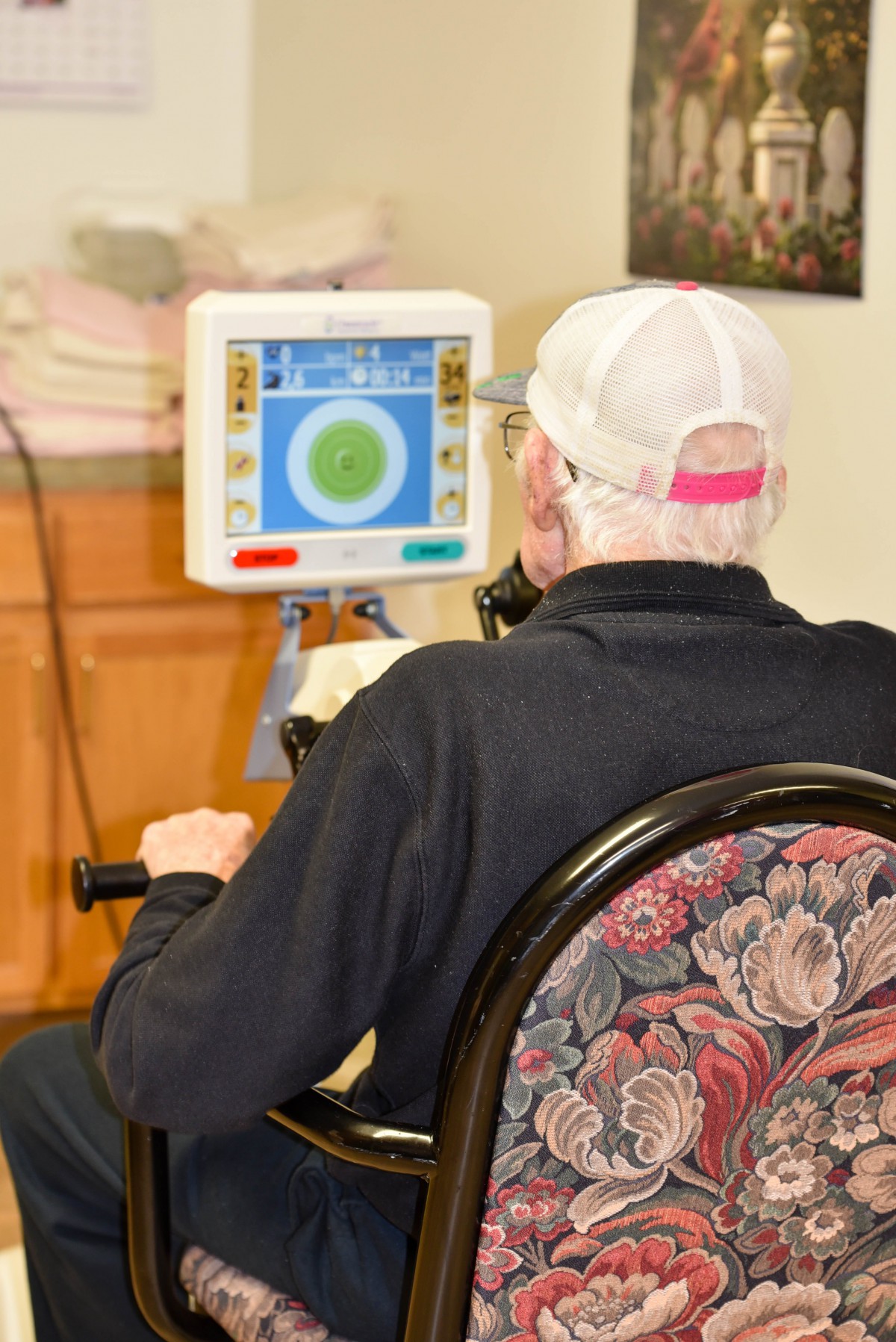 An elderly person exercises using a digital rehabilitation machine.