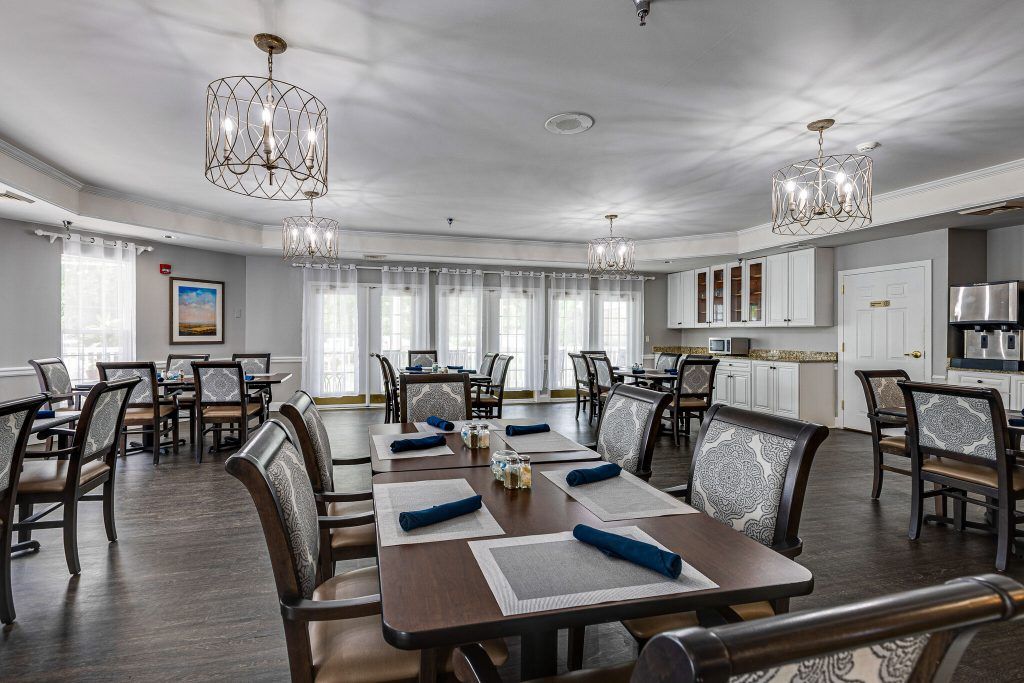 A modern dining room with neatly arranged tables and chandeliers.