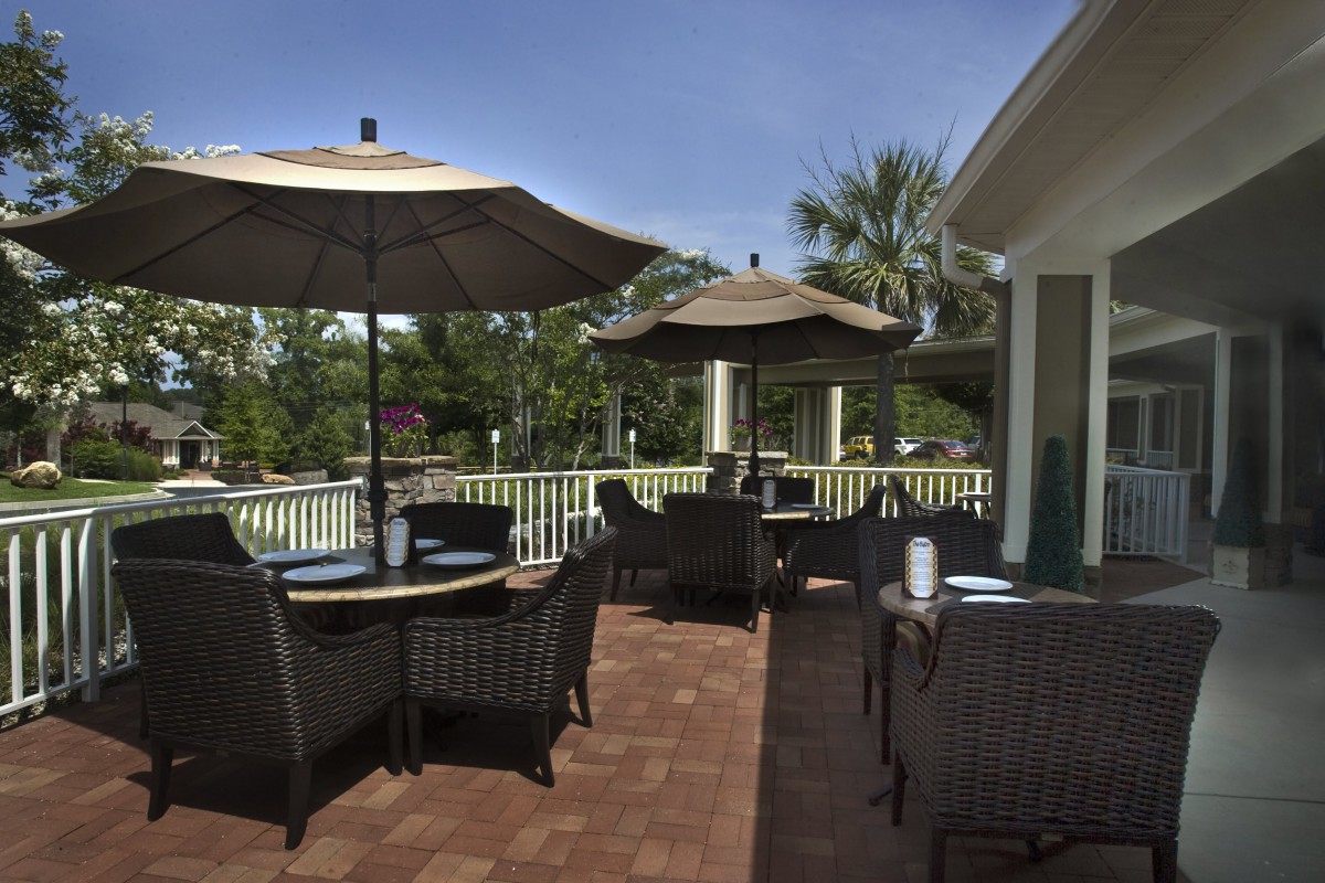 A cozy outdoor patio with seating and umbrellas on a sunny day.