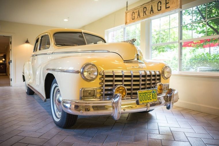 A vintage car displayed in an indoor garage setting.