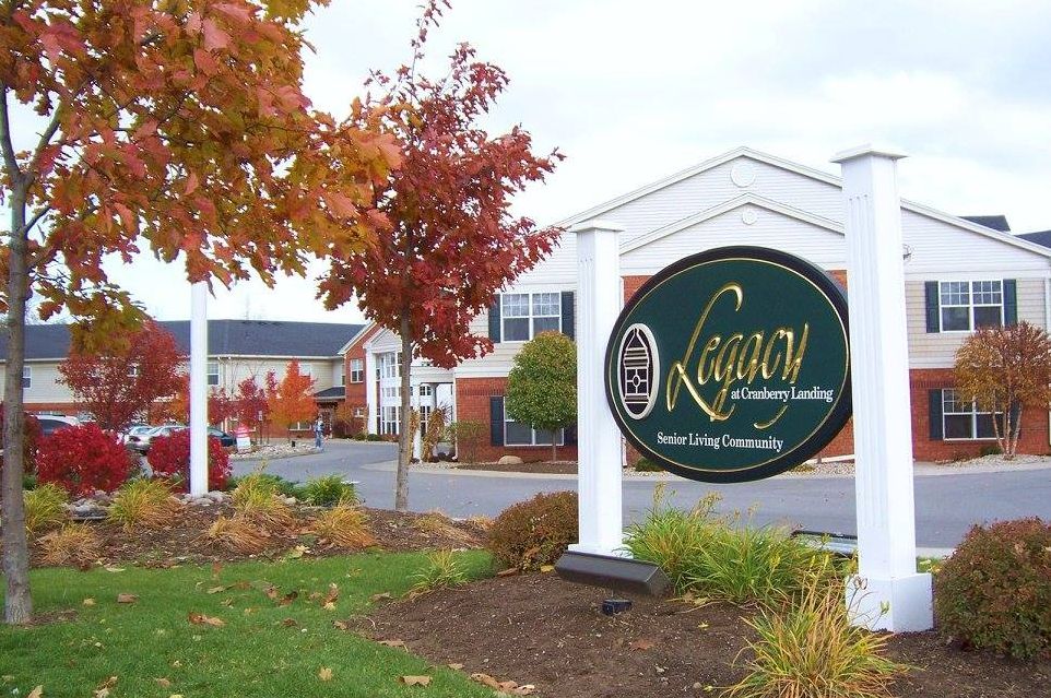 The entrance to a residential community with autumn foliage and well-maintained landscaping.