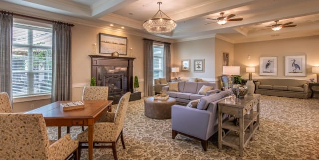 A cozy and elegantly designed living room with a fireplace, featuring a comfortable sofa, coffee table, and dining area.