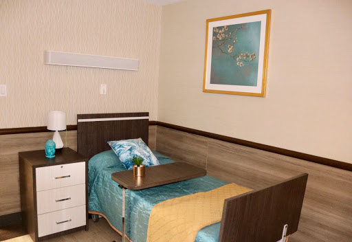 A tidy and modern hospital room equipped with a patient bed and bedside amenities.