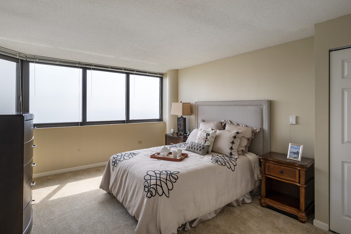A cozy bedroom with a large window and stylish decor.