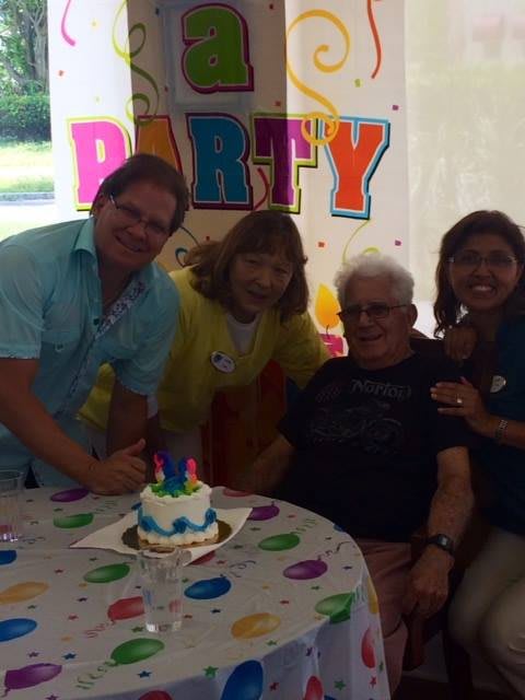 A group of people celebrating a birthday with cake at a party.
