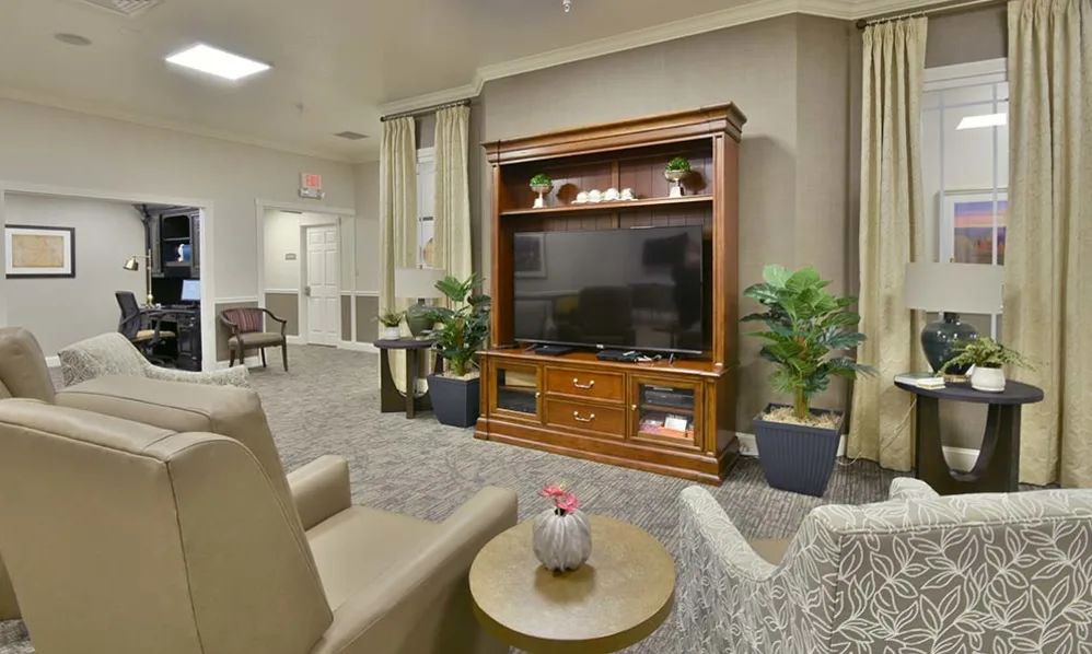 A cozy living room with a large TV cabinet and comfortable seating.