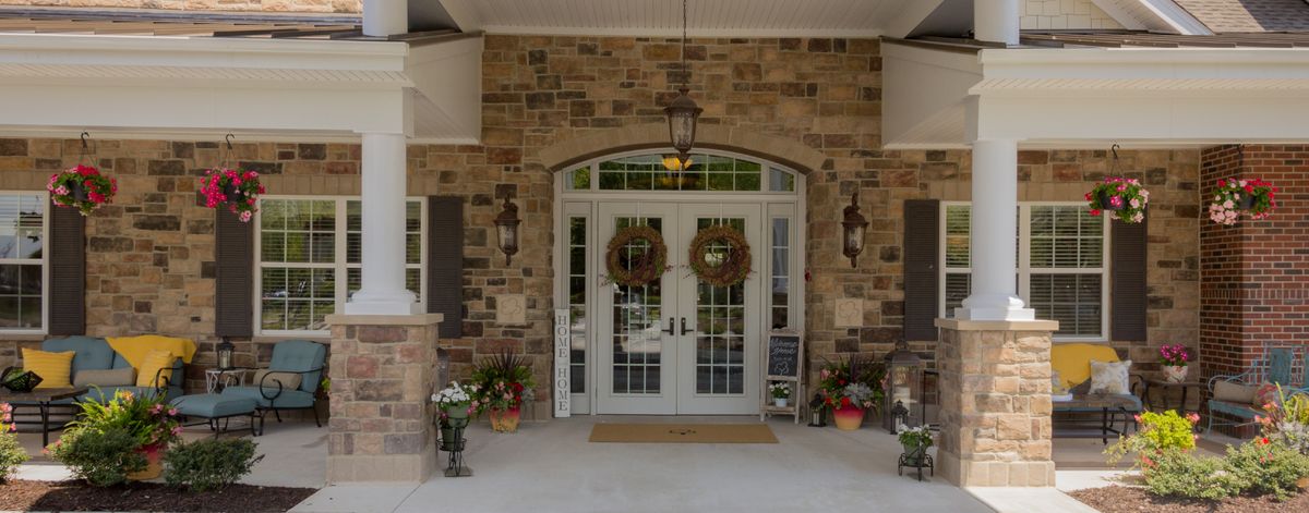 A charming entrance with decorative wreaths and potted plants accenting a brick facade.