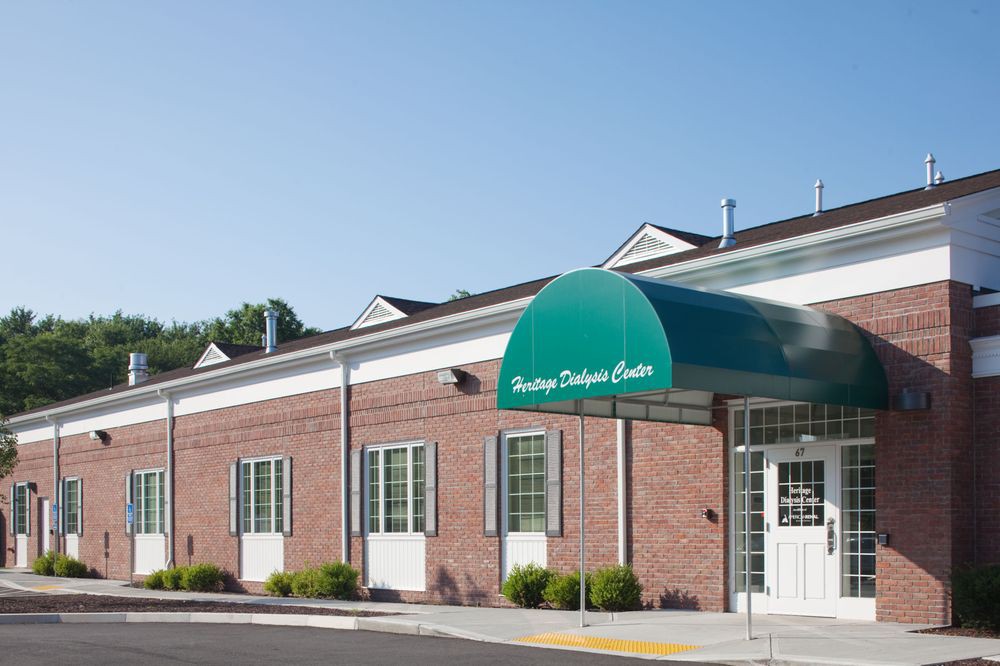 A brick building with a green awning over the entrance.