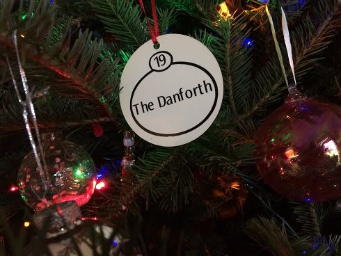 A Christmas tree ornament labeled 'The Danforth' hanging amidst colorful lights.