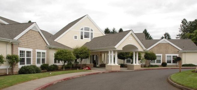 A well-maintained residential building with a covered entrance and ornamental columns.