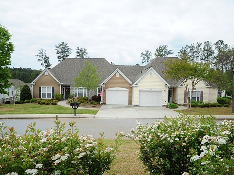 A suburban neighborhood with two attached houses, featuring driveways and landscaped yards.