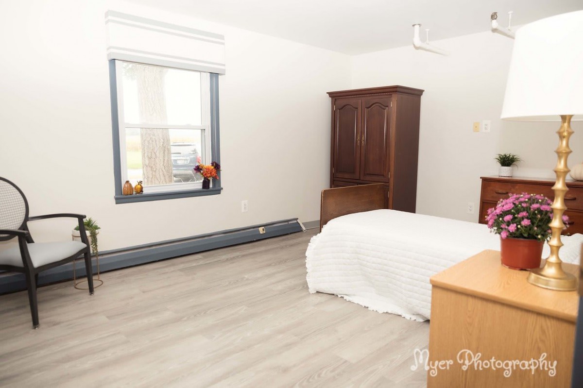 A minimalist bedroom with a bed, wardrobe, and window.