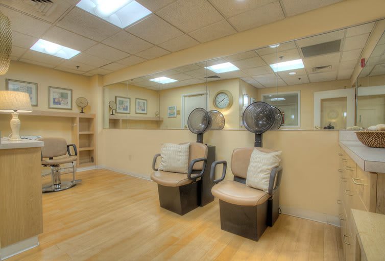 A tranquil hair salon interior with seating and hair dryers, ideal for a relaxing beauty treatment.