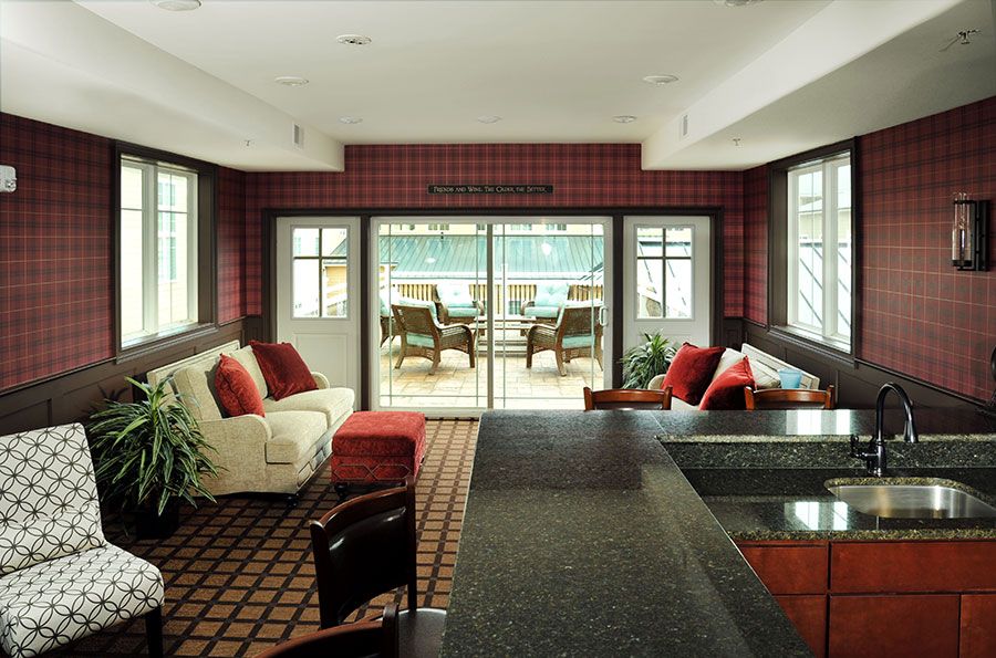 A modern living room with a view of the patio, featuring comfortable seating and stylish decor.