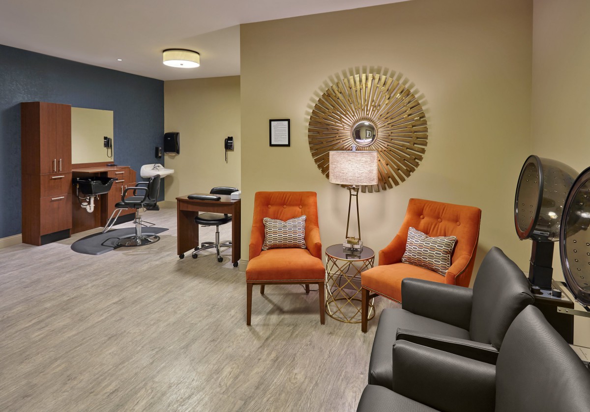 A cozy waiting room with bright orange chairs and stylish decor.