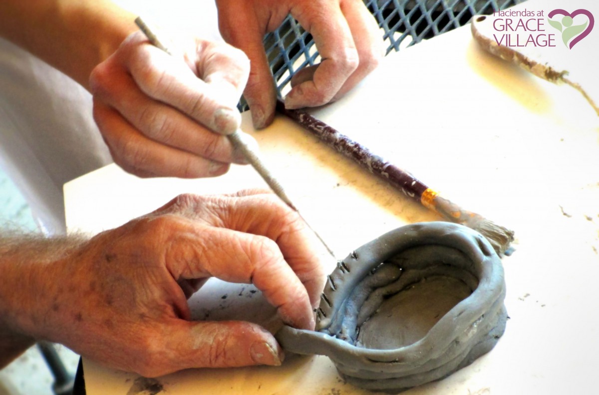 Hands crafting a clay pottery piece.