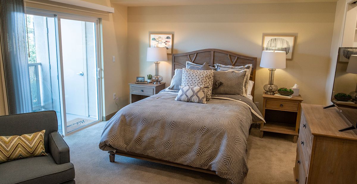 A cozy bedroom interior with a neatly made bed and stylish decor.