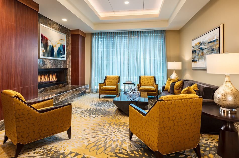 A cozy living room with elegant furnishings, featuring a fireplace and art on the walls.