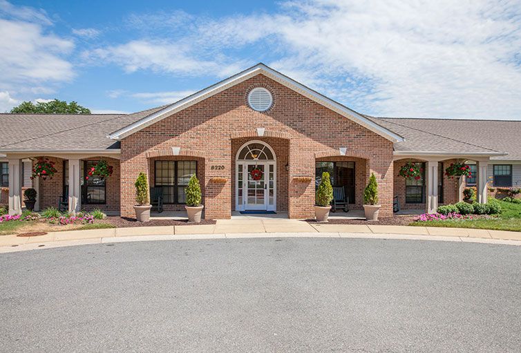 A symmetrical brick building with a central entrance and clear sky above.
