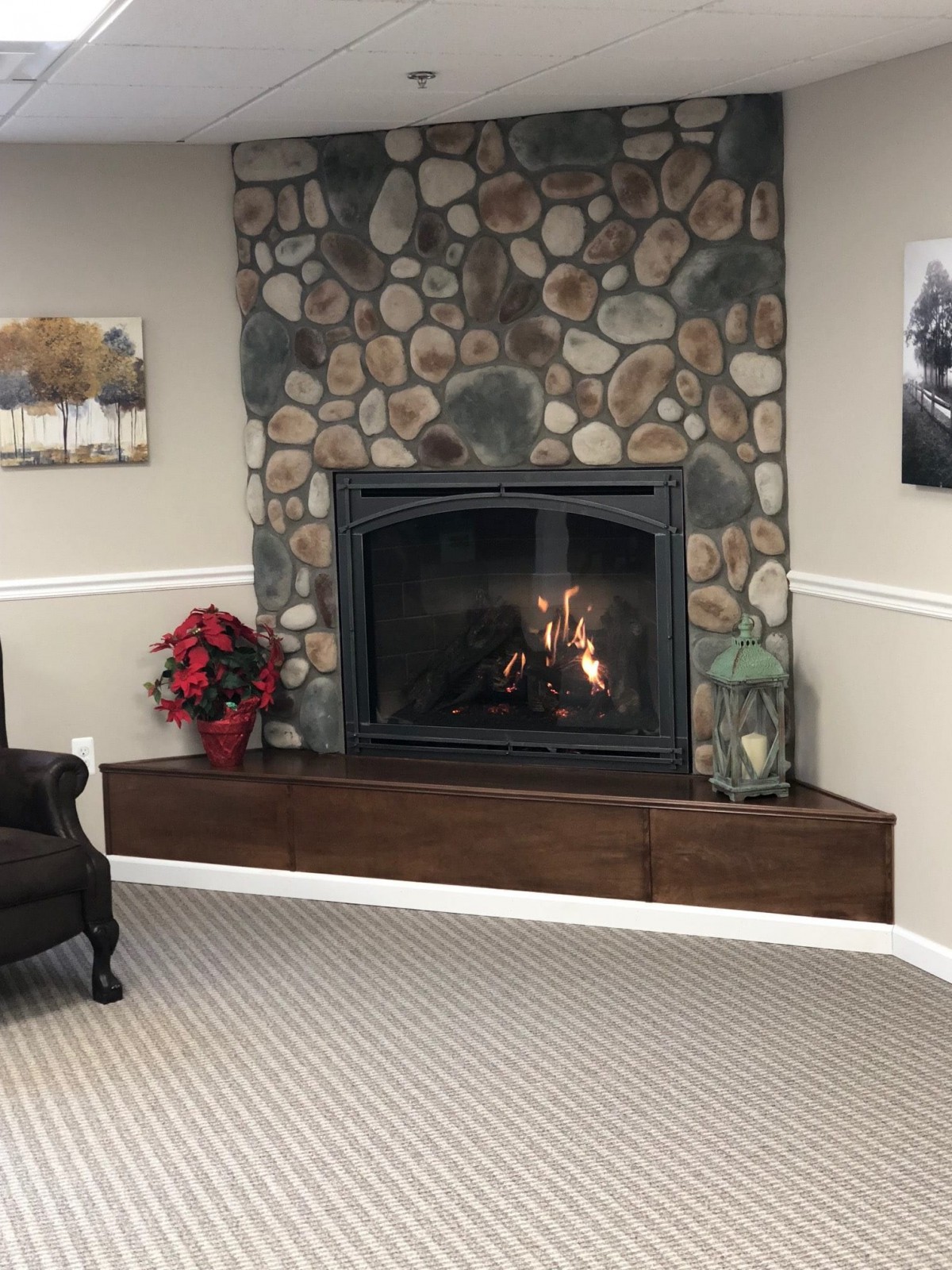 A cozy living room with a stone fireplace and comfortable seating.