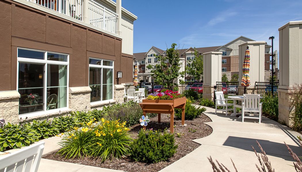 A well-maintained community garden area with planter boxes in an apartment complex.