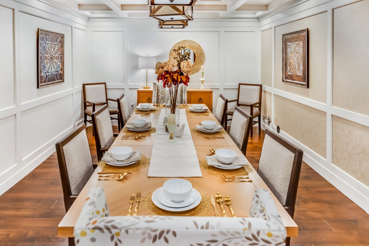 An elegantly set dining table with a decorative centerpiece in a well-designed room.