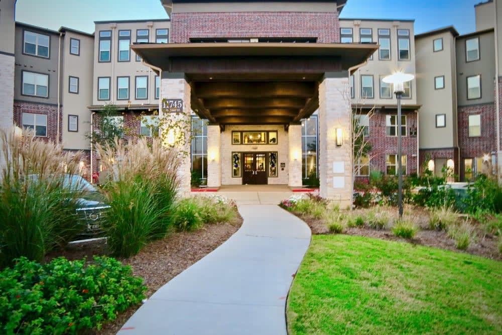A modern building entrance with a landscaped pathway leading to its doors.