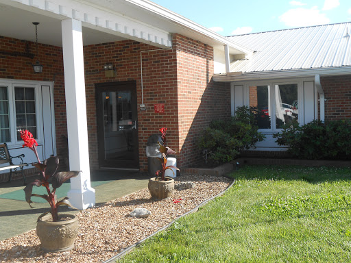 A welcoming entrance to a brick house with landscaped greenery.