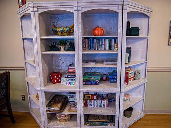 A bookshelf filled with books, board games, and decorative items.