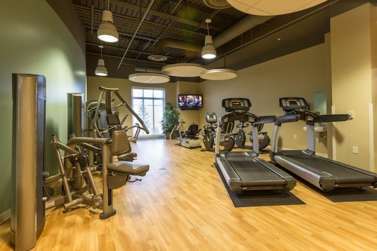 A modern gym with various exercise equipment, including treadmills and weight machines.