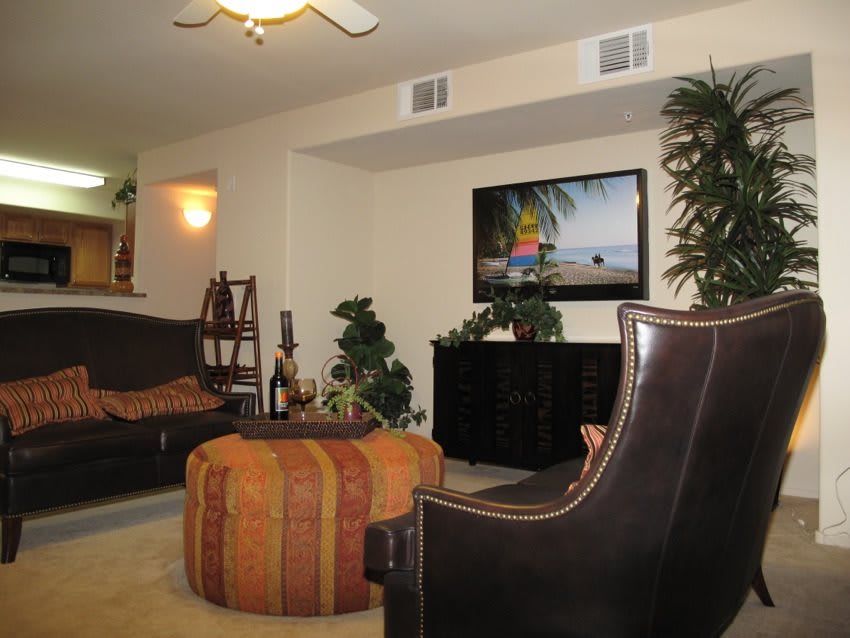 A cozy living room with modern furniture and a television mounted on the wall.