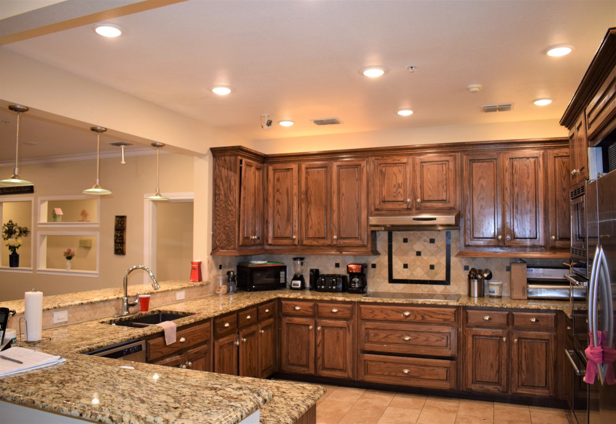 A spacious kitchen featuring wooden cabinets, granite countertops, and modern appliances.