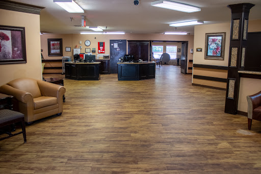A spacious and well-lit lobby area featuring wooden flooring and comfortable seating.