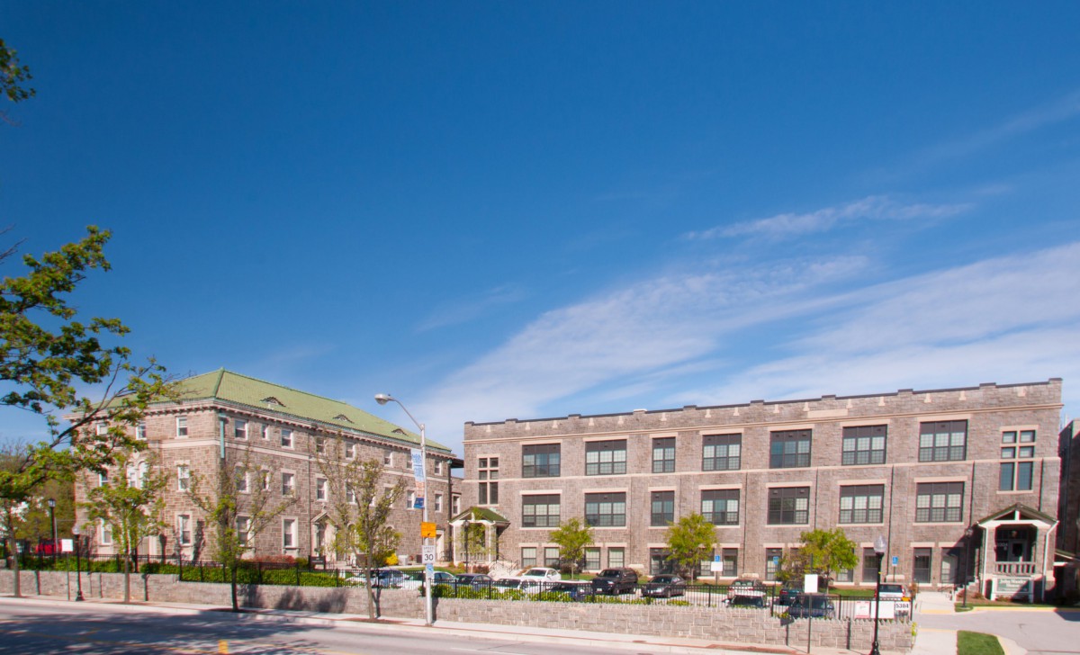A city street with brick buildings under a clear blue sky.