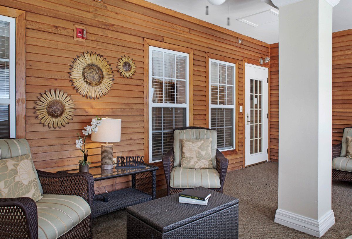 A cozy indoor seating area with wooden walls, cushioned chairs, and decorative accents.