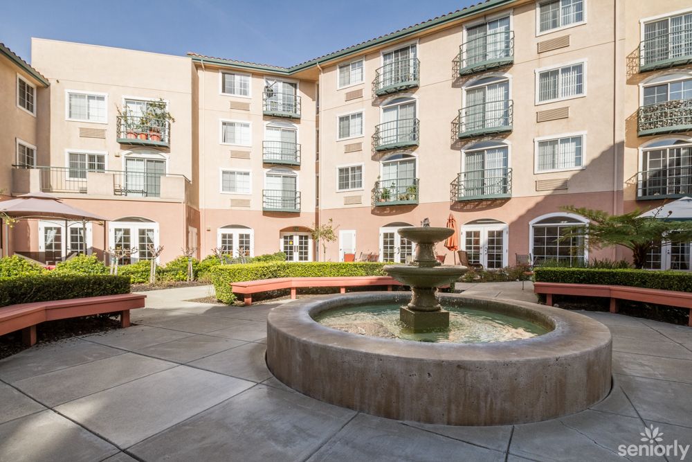 A serene courtyard with a central fountain surrounded by residential apartments.