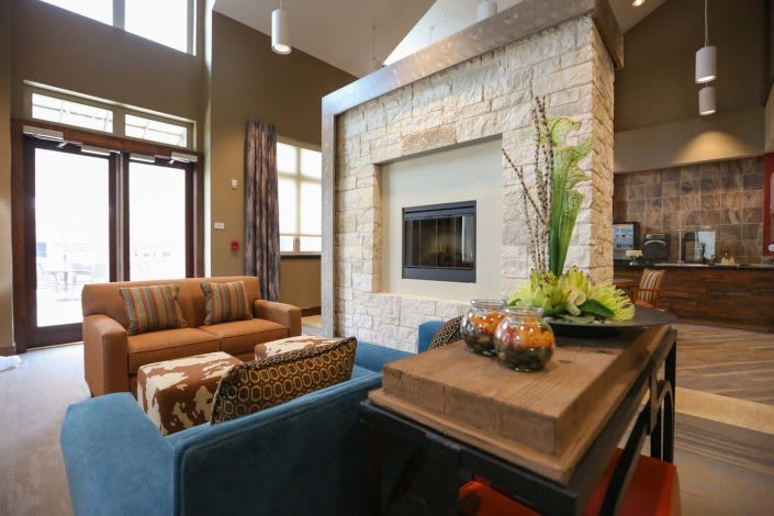 A modern living room with a central fireplace and comfortable seating.