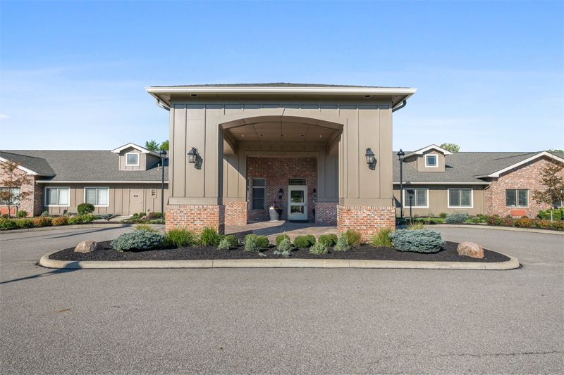 A modern building entrance with neatly landscaped surroundings.