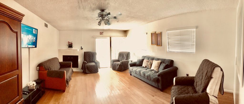 A cozy living room with a sofa, armchairs, and wood flooring.