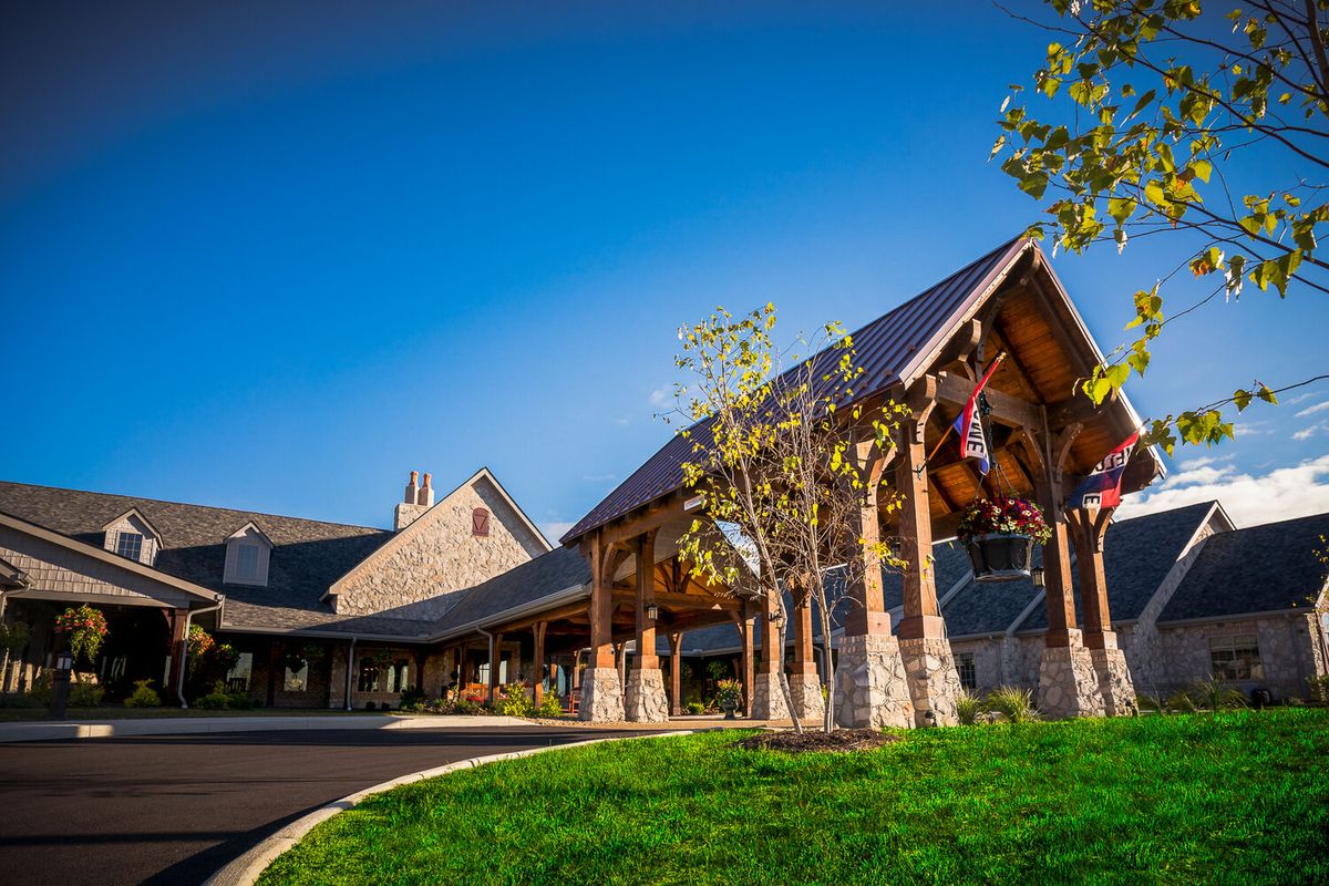 A picturesque log-style building with a wooden entrance set against a clear blue sky.