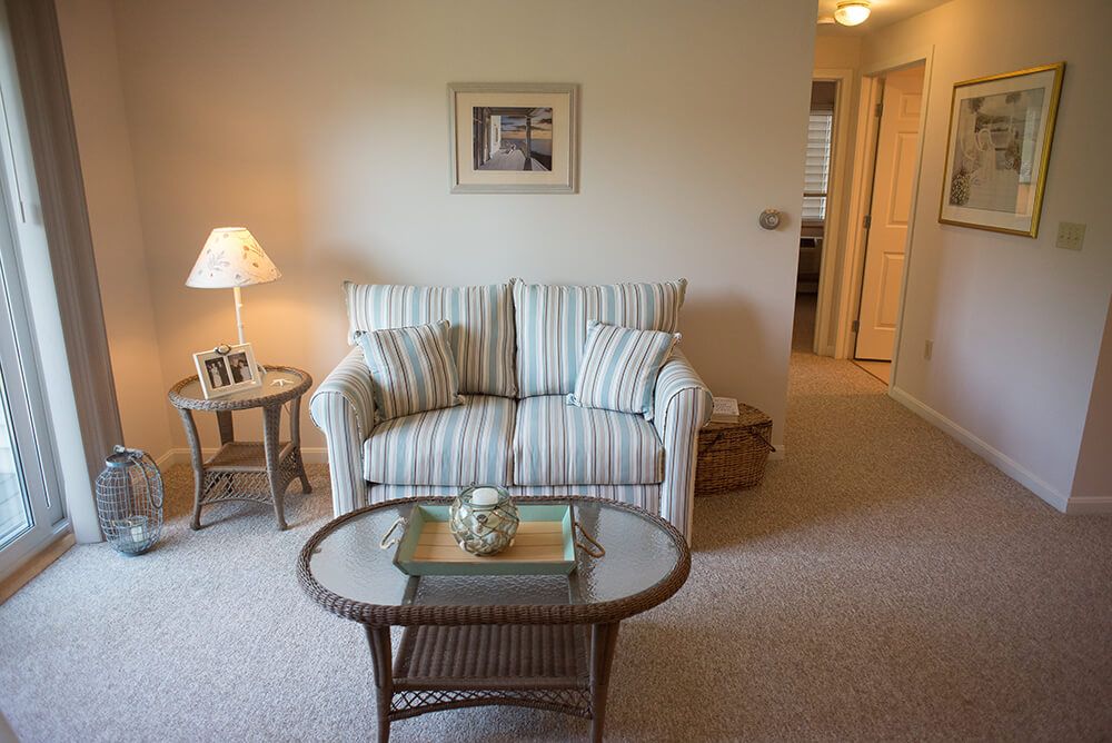 A cozy living room featuring a striped sofa and a glass-topped coffee table.