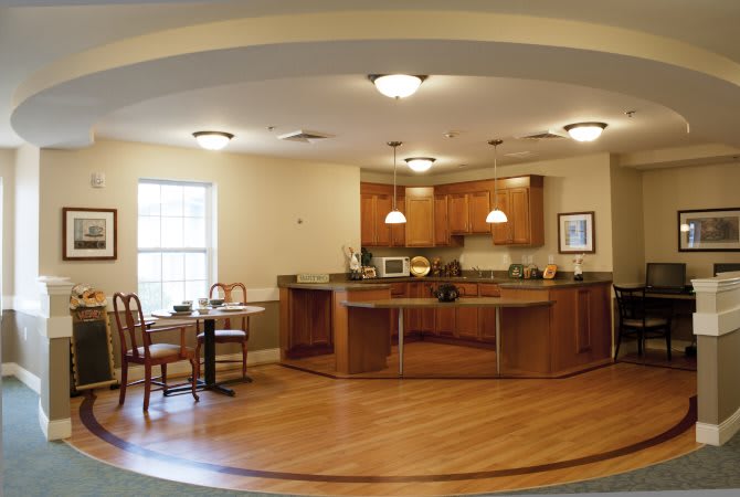A modern kitchen and dining area featuring wooden cabinetry and flooring.