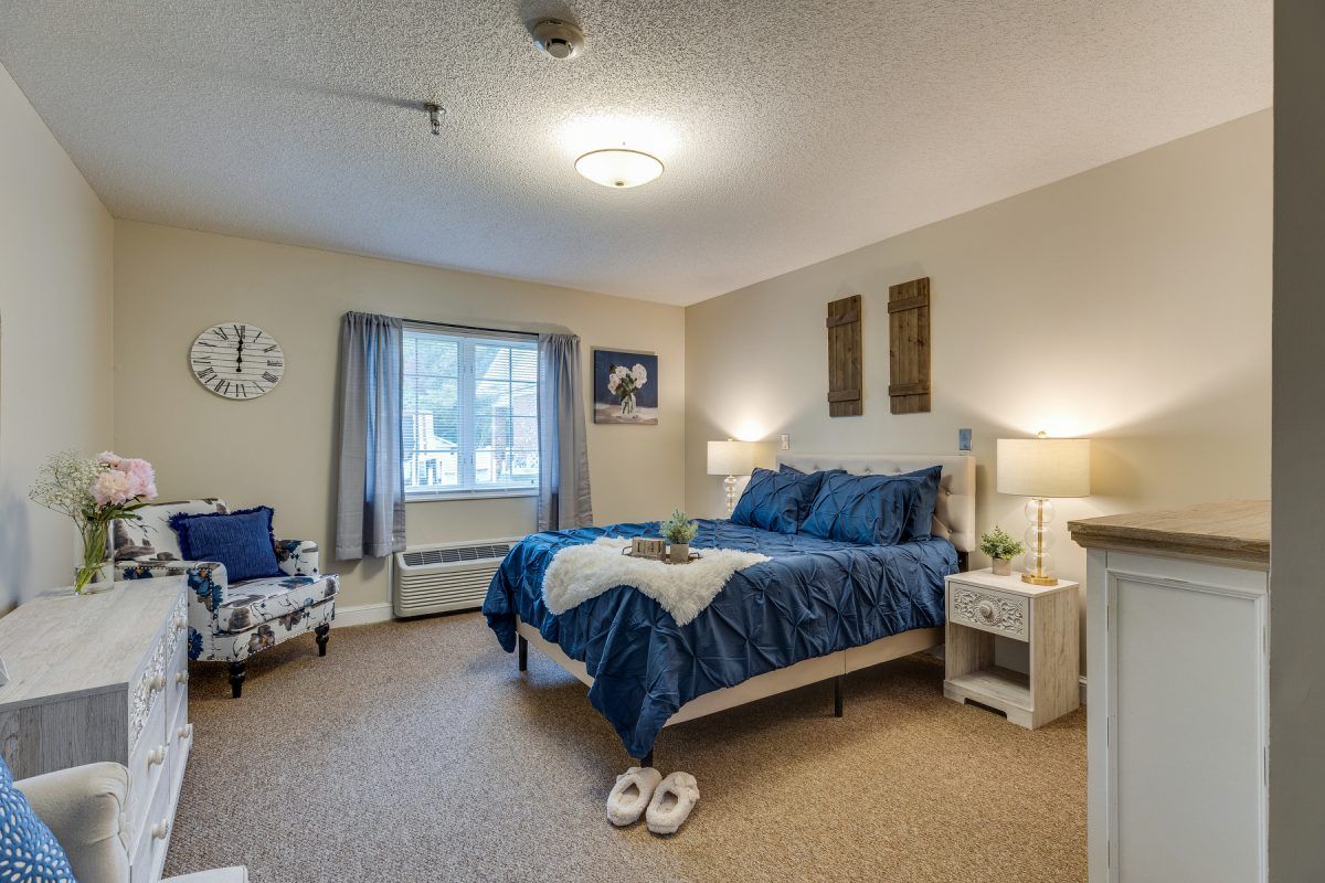 A cozy bedroom with blue bedding and warm lighting.