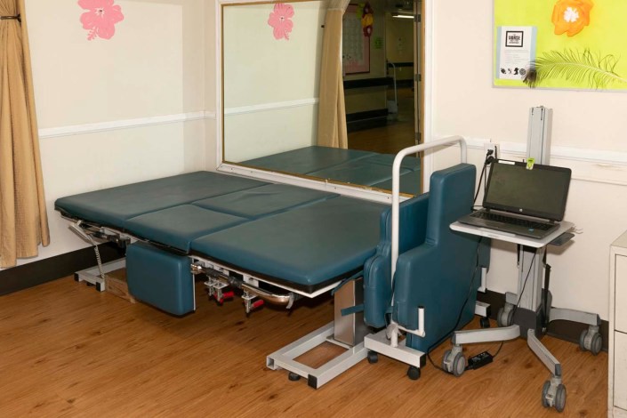 A physical therapy room with a specialized therapy table and equipment.